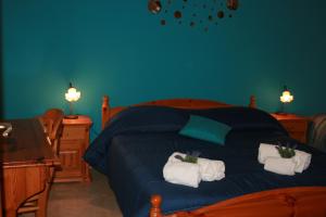 una camera da letto con un letto blu e asciugamani di Casa Vacanze Il Cortile a Custonaci