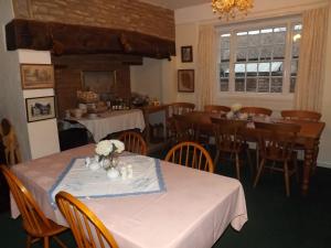 uma sala de jantar com mesas e cadeiras com toalha de mesa branca em Peartree Farm em Aldwincle Saint Peter