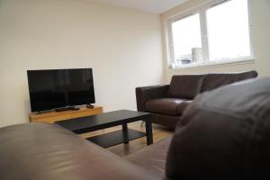 a living room with a couch and a flat screen tv at Spacious Home Dundee in Dundee