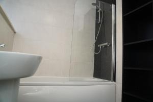 a shower with a glass door next to a sink at Spacious Home Dundee in Dundee