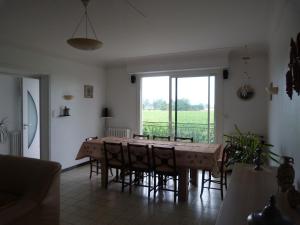 a dining room with a table and chairs and a window at Gite La Rizière in Vic-en-Bigorre