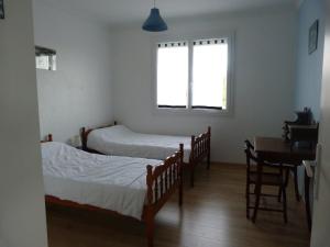 a bedroom with three beds and a table and a window at Gite La Rizière in Vic-en-Bigorre