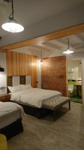 une chambre avec deux lits et un mur de briques dans l'établissement Mr. Buster B&B, à Hualien