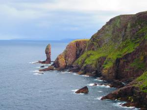 a rocky coastline with rocks in the water at 28 Hillside in Lochinver