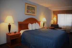 a hotel room with a bed with a blue blanket at Texas Inn & Suites in Denton
