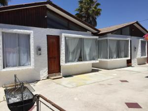 a white house with windows and a door at Cabañas Herradura Oriente in Coquimbo