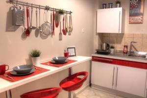 a kitchen with red chairs and a counter with utensils at Fairytale view of Lycabettus in Athens