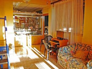 Hotel Rozal Spa Iquique في إكيكي: غرفة معيشة مع أريكة ومكتب مع جهاز كمبيوتر