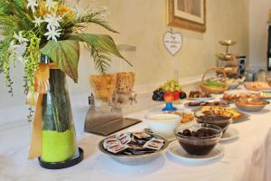 a table topped with plates of food and desserts at Hotel Flora in Bellaria-Igea Marina