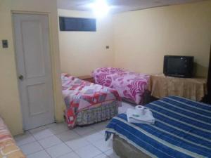 uma sala de estar com duas camas e uma televisão em Hotel Rozal Spa Iquique em Iquique