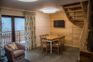 a dining room with a table and chairs and a tv at Krzywy Zakątek in Cisna