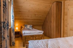 a room with two beds in a log cabin at Krzywy Zakątek in Cisna