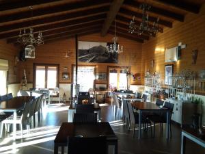 un restaurante con paredes de madera, mesas y sillas en Casa del Valle, en Hinojosas de Calatrava