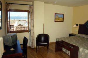 um quarto com uma cama, uma televisão e uma janela em Hotel Spa La Casa Mudéjar na Segóvia