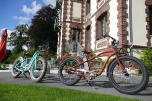 duas bicicletas estacionadas em frente a um edifício em Villa Argonne em Ouville-la-Rivière