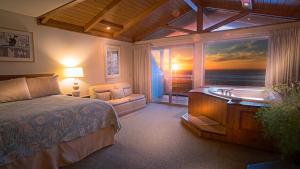 Schlafzimmer mit einem Bett, einer Badewanne und einem Fenster in der Unterkunft Inn of the Lost Coast in Shelter Cove