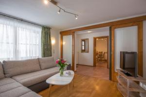 a living room with a couch and a table at Appartement Holzleiten in Jochberg