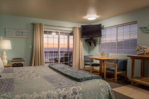 Schlafzimmer mit einem Bett, einem Tisch und einem TV in der Unterkunft Inn of the Lost Coast in Shelter Cove