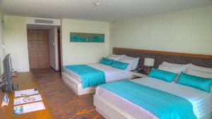 a hotel room with two beds and a television at Estelar Playa Manzanillo - All inclusive in Cartagena de Indias