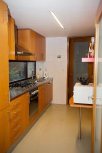 uma cozinha com armários de madeira e um forno com placa de fogão em Civitá Design & Accommodation em Braga