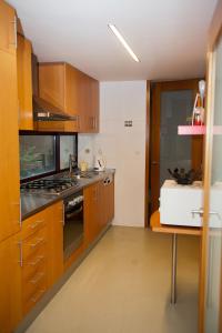 a kitchen with wooden cabinets and a stove top oven at Civitá Design & Accommodation in Braga