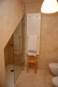 a bathroom with a shower and a toilet and a stool at Civitá Design & Accommodation in Braga
