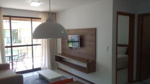 a living room with a tv on a wall at Apartamento Iloa Residence in Barra de São Miguel