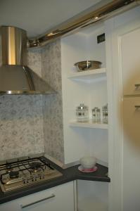 a kitchen with a stove and some shelves at Casa Duomo in Amalfi