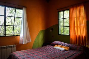 a bedroom with a bed and two windows at Casa Grande Hostel in Merlo +89 photos