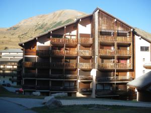 a building with balconies and a mountain in the background at résidence le bois gentil in Auris