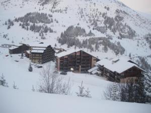 un lodge de esquí en la nieve en una montaña en résidence le bois gentil en Auris