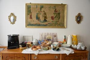 a table with food on it with a picture on the wall at B&B" del Castello" in Roccascalegna