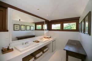 uma casa de banho com 2 lavatórios e um espelho em Pousada Tutabel em Trancoso