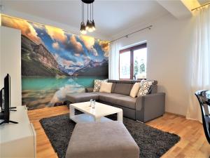 a living room with a large painting on the wall at VIP Apartamenty Carmelove in Zakopane