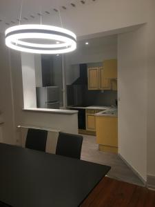 una cocina con una mesa y una lámpara grande en JLGR3, en Belfort 4 fotos más