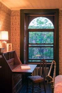 a desk in a room with a window and a desk with a chair at The Harlem Flophouse in New York