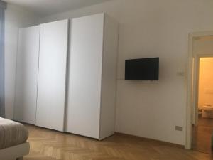 a bedroom with white cabinets and a flat screen tv at Appartamento Nadia in Merano