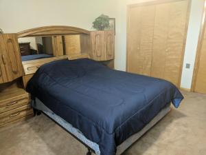 a bedroom with a bed with a blue comforter at DIA BnB - We love workers in Brighton