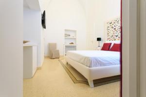 a white bedroom with a bed and a fireplace at Palazzo Casto Relais in Taviano +59 photos