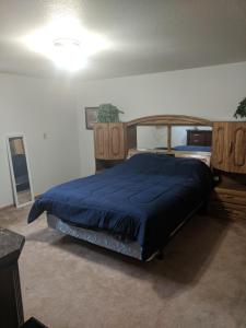 a bedroom with a bed with a blue comforter at DIA BnB - We love workers in Brighton