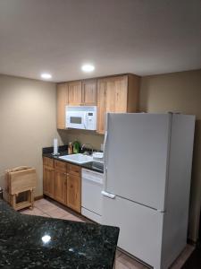 a kitchen with a white refrigerator and wooden cabinets at DIA BnB - We love workers in Brighton