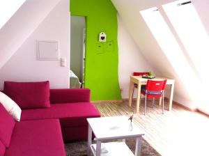 - un salon avec un canapé rouge et une table dans l'établissement Ferienwohnung Schau ins Dorf, à Ostercappeln