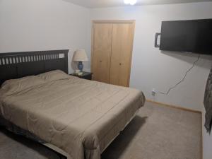 a bedroom with a bed and a flat screen tv at DIA BnB - Mountain View - Private floor - DIA Layover - Great entertainment and bed in Brighton