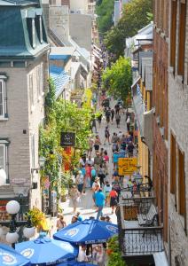 魁北克市的住宿－Auberge Jeunesse La Belle Planete Backpackers Hostel，一群人用遮阳伞沿着街道走着