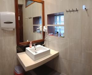 y baño con lavabo blanco y espejo. en Highland Resort & Nature Tours, en Tomohon