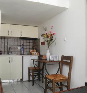 a kitchen with a table and chairs and a table with flowers at Ζoe Studios in Kýthira