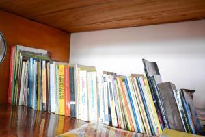 a row of books sitting on a book shelf at Mount Mary Inn in Nuwara Eliya