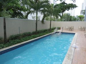 una piscina con agua azul y palmeras en Flats Beach Class Convention Residence, en Recife