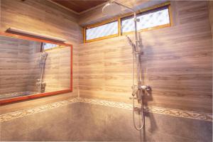 a bathroom with a shower with a glass door at Shaxi Aoding Courtyard in Jianchuan