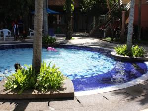 a pool with a palm tree and a person in it at FnF Suite @ Time Square in Kuala Lumpur